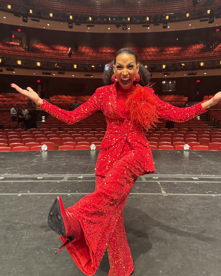 Chelsea striking a pose center stage in a red sequin suit